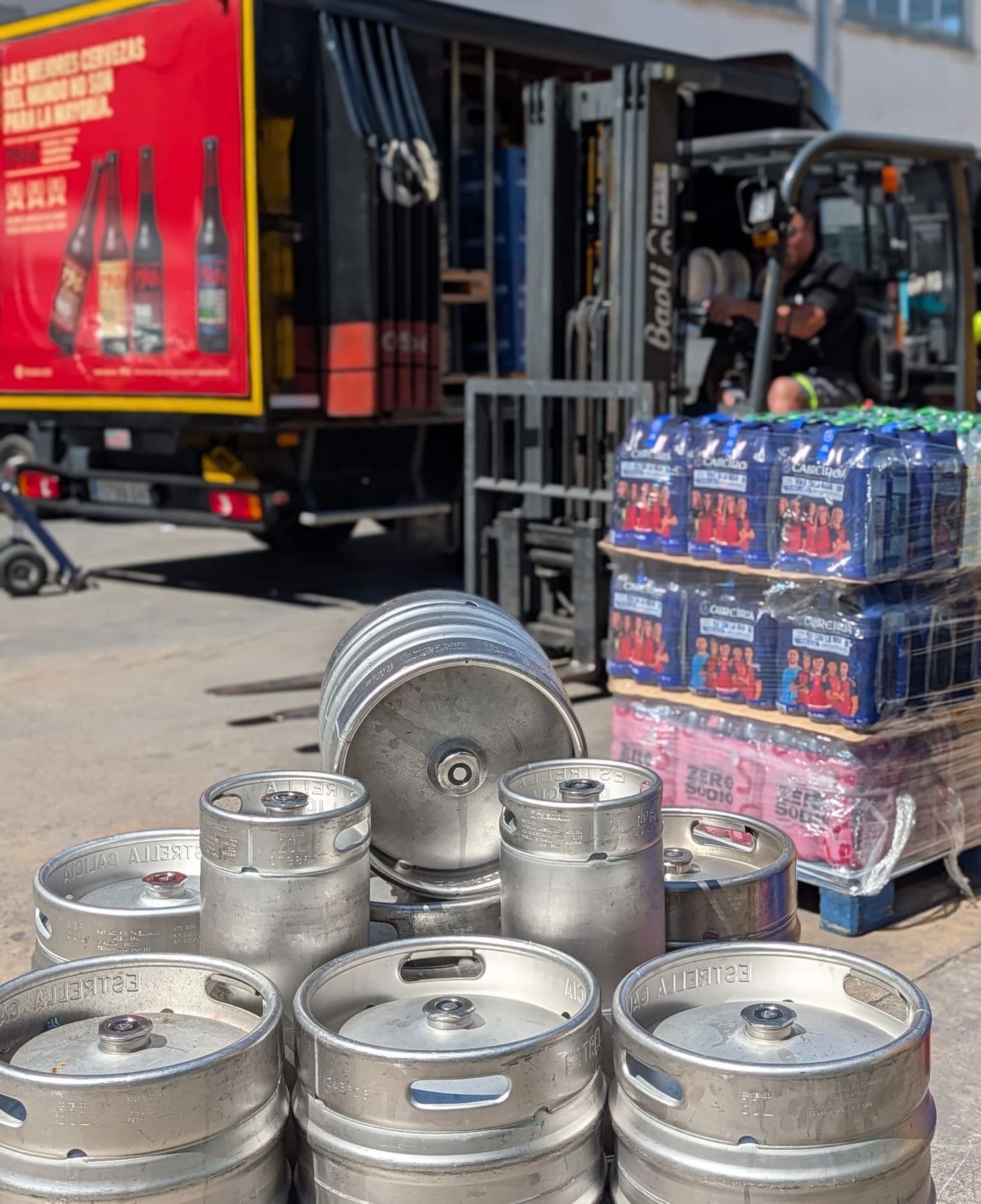Barriles de cerveza apilados junto a un camión de reparto de Aracaba