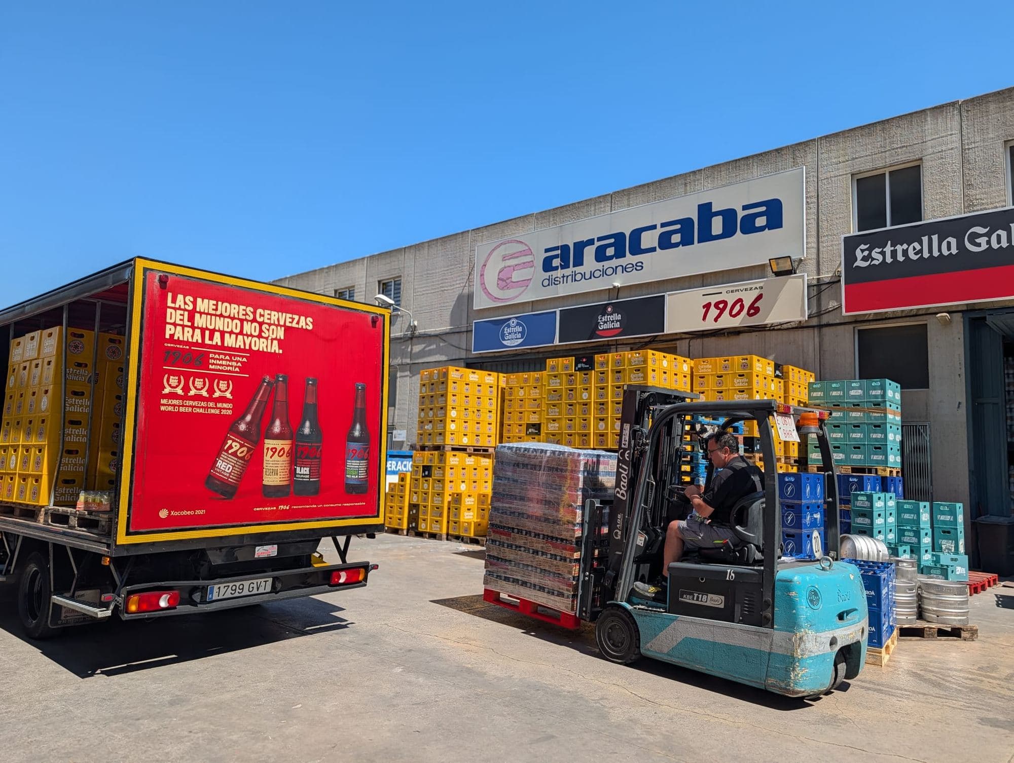 Patio del almacén de Aracaba con un camión de reparto y una carretilla moviendo palés de bebidas